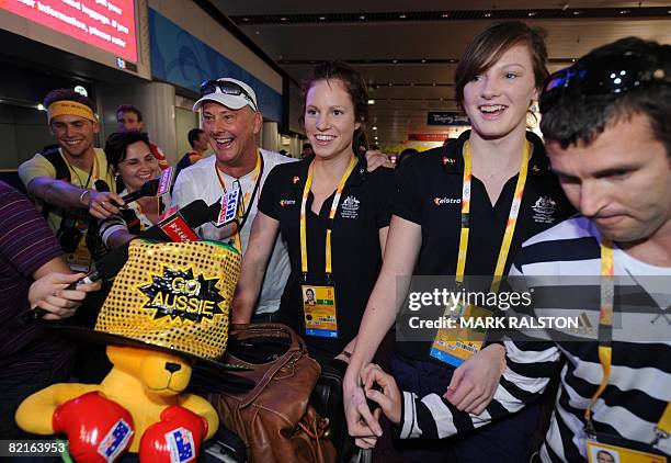 Australian swimmers Emily Seebohm and Cate Campbell walk with team officials and a boxing kangaroo as they arrive at the Beijing International...