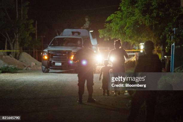 Police officers guard the scene of a shooting in Puerto Morelos, Mexico, on Tuesday, July 11, 2017. The narco-traffickers already hold sway over...