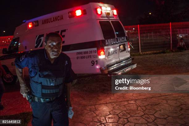 Police officer guards an ambulance carrying a shooting victim in front of the General Hospital in Cancun, Mexico, on Tuesday, July 11, 2017. The...