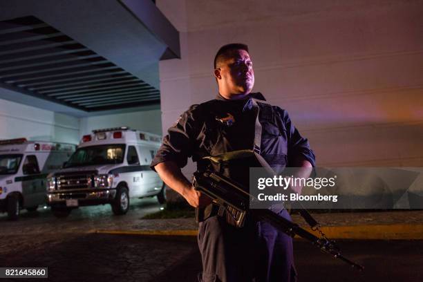Police officer stands guard outside after a shooting victim was brought to the General Hospital in Cancun, Mexico, on Tuesday, July 11, 2017. The...