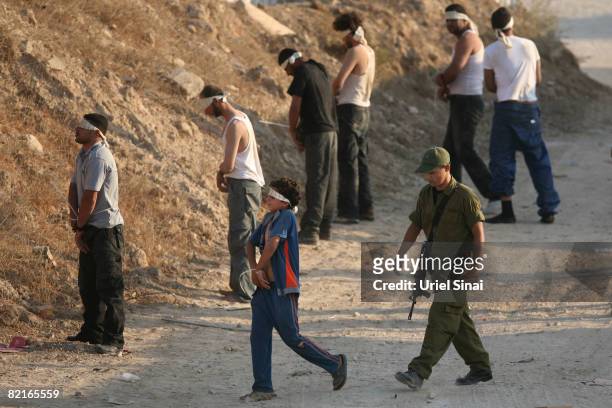 Fatah fighters who fled from Hamas gunmen in the Gaza Strip during the night and a young boy are detained at an Israeli army base on August 3, 2008...