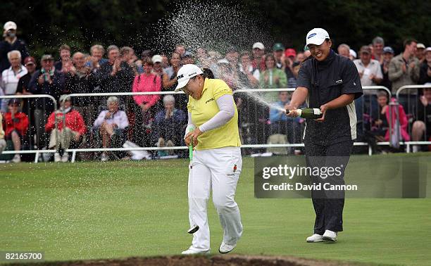 Ji-Yai Shin of South Korea is sprayed with champagne on the 18th green after holing the winning putt by fellow Korean golfer Amy Yang during the...