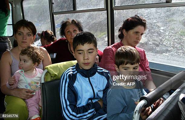 Refugees from a maverick Georgian region of South Ossetia sit in a bus upon their arrival to Russian territory in a village of Tamisk, some 50...