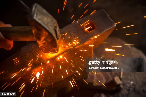 een hamer verslaan oorzaken sparks - smederij stockfoto's en -beelden