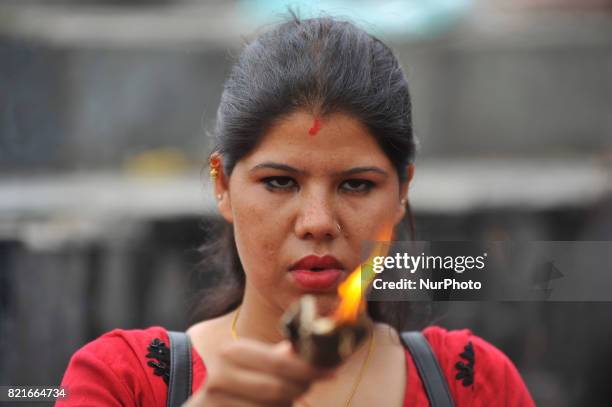 Nepalese devotee offering butter lamps during Shrawan Sombar festival at the premises of Pashupatinath Temple, Kathmandu, Nepal on Monday, July 24,...