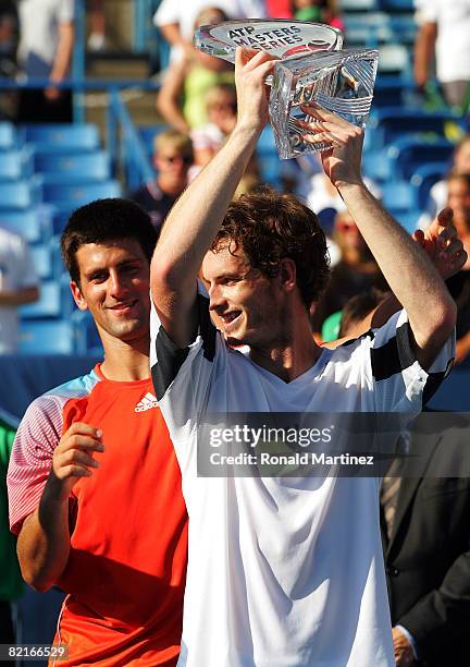 Andy Murray of Great Britain raises his trophy with help from Novak Djokovic after a 7-6,7-6 win in the finals of the Western & Southern Financial...