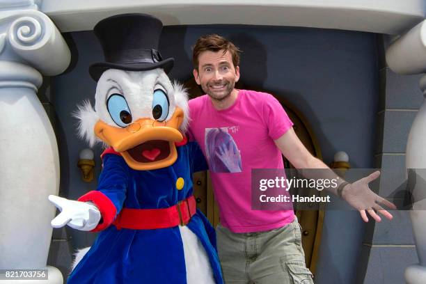 In this handout photo provided by Disney Parks, actor David Tennant poses with Scrooge McDuck, who made a special appearance in Mickeys Toontown July...