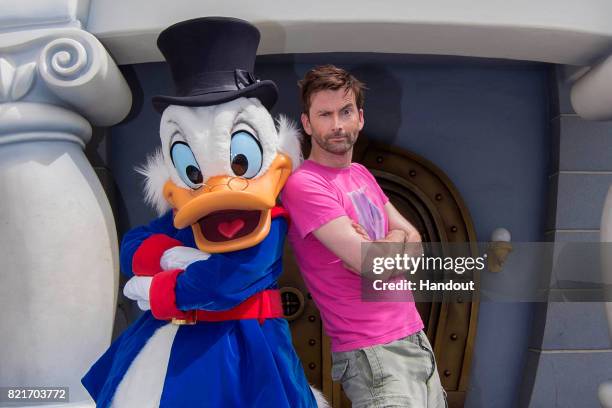 In this handout photo provided by Disney Parks, actor David Tennant poses with Scrooge McDuck, who made a special appearance in Mickeys Toontown July...