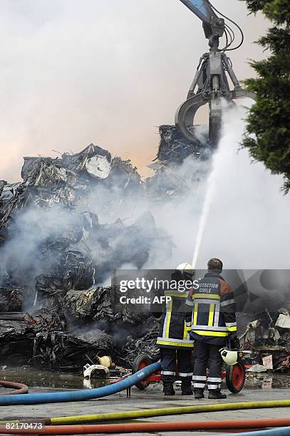 Firefighters douse a fire at car recycling company Comet Sambre SA, in Chatelet on August 4, 2008. The fire has been rageing overnight after...