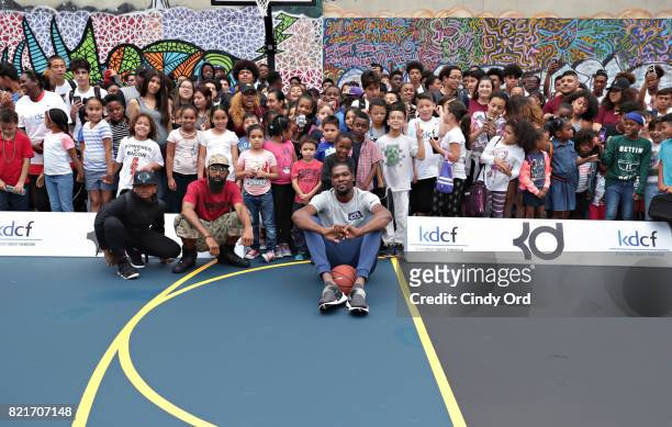 Professional basketball player Kevin Durant poses with students during the KD Build It and They Will Ball court ceremony on July 24, 2017 in New York...