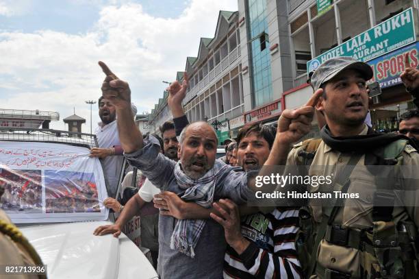 Supporter of Independent MLA Engineer Rashid shouts slogan as policemen detained him during his protest march against the beating of policemen by...