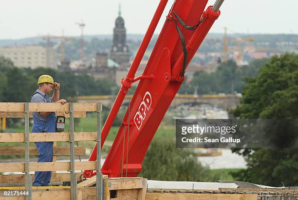 The Elbe River flows behind a worker at the controversial Waldschloesschen Bridge construction site on August 4, 2008 in Dresden, Germany. The...