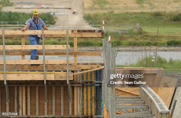 The Elbe River flows behind a worker at the controversial Waldschloesschen Bridge construction site on August 4, 2008 in Dresden, Germany. The...