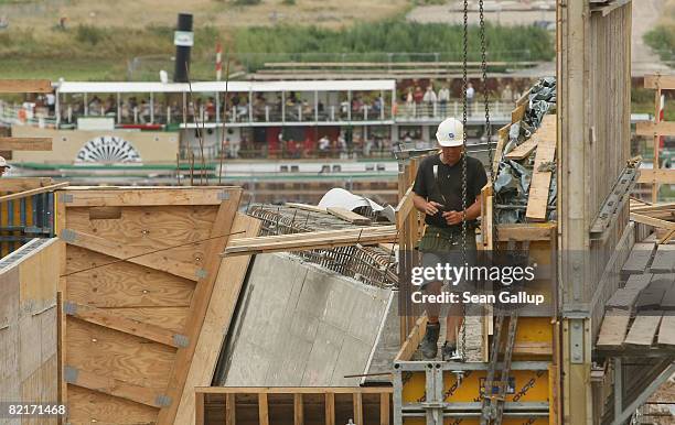 Tourist boat travels along the Elbe River behind a worker at the controversial Waldschloesschen Bridge construction site on August 4, 2008 in...
