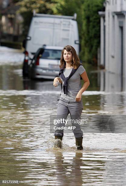 Woman walks across a flooded street of Court-Saint-Etienne on August 4, 2008. Several towns of the Walloon Brabant province were flooded after heavy...