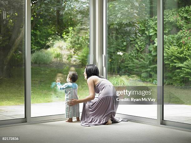 mother and son looking out window - family rear view stock pictures, royalty-free photos & images