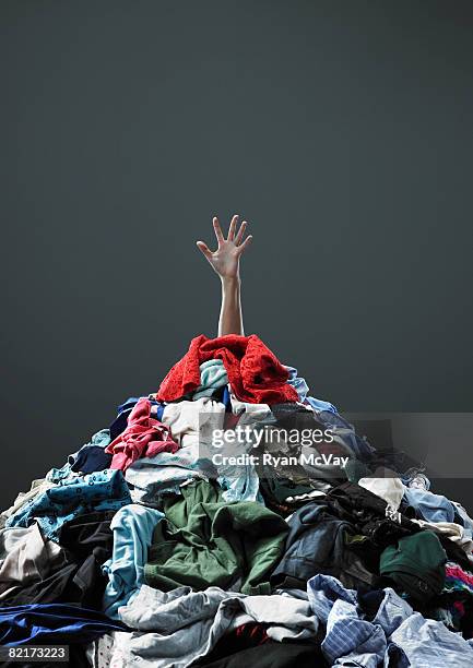 hand coming out of pile of clothing - hand washing stockfoto's en -beelden