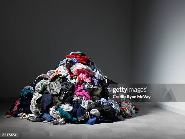 große haufen von kleidung in einem leeren zimmer. - clothes stock-fotos und bilder
