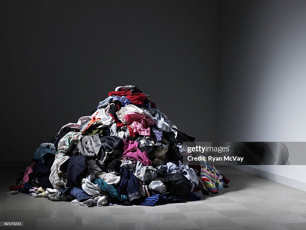 Amplio pila de ropa en una habitación vacía.