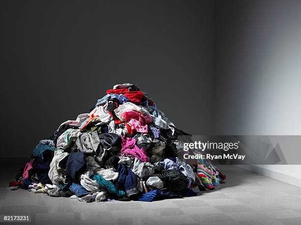 large pile of clothes in an empty room. - kläder bildbanksfoton och bilder