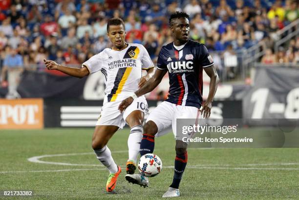 Los Angeles Galaxy forward Giovani dos Santos moves in on New England Revolution midfielder Gershon Koffie during a regular season MLS match between...