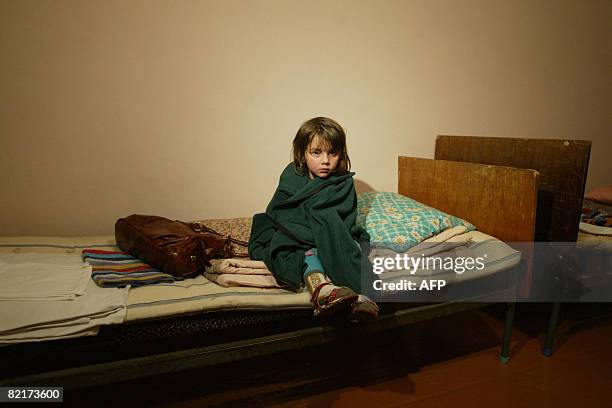 Refugee girl from the maverick Georgian region of South Ossetia sits on a bed after her arrival to Russian territory in Vladikavkaz, the capital of...
