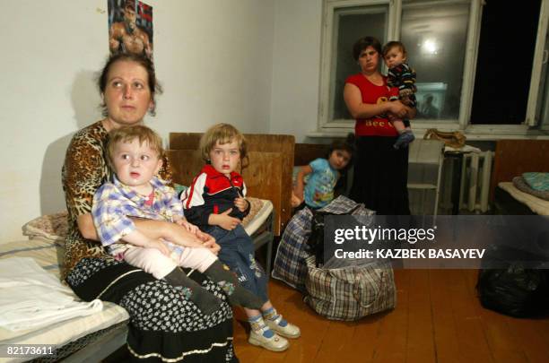 Refugees from the maverick Georgian region of South Ossetia sit on a bed after their arrival to Russian territory in Vladikavkaz, the capital of...