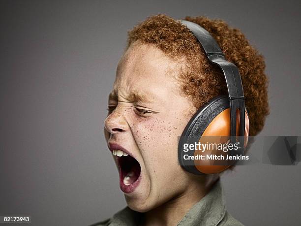 boy shouting with ear defenders - orejeras fotografías e imágenes de stock
