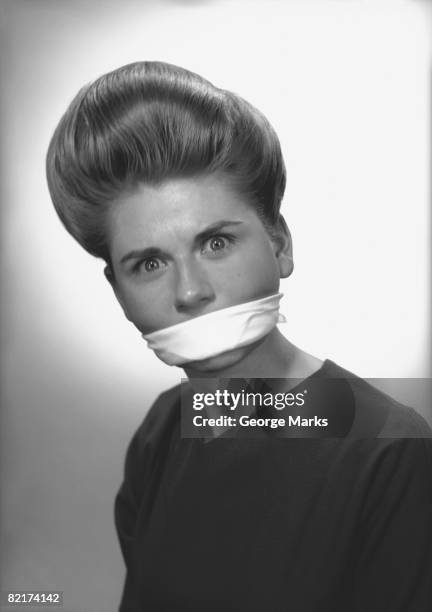 woman with covered mouth in studio, (b&w), portrait - gagged woman stock-fotos und bilder