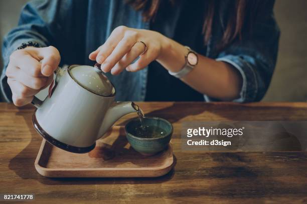 woman enjoying a quiet time with a fresh cup of tea - green tea stock-fotos und bilder