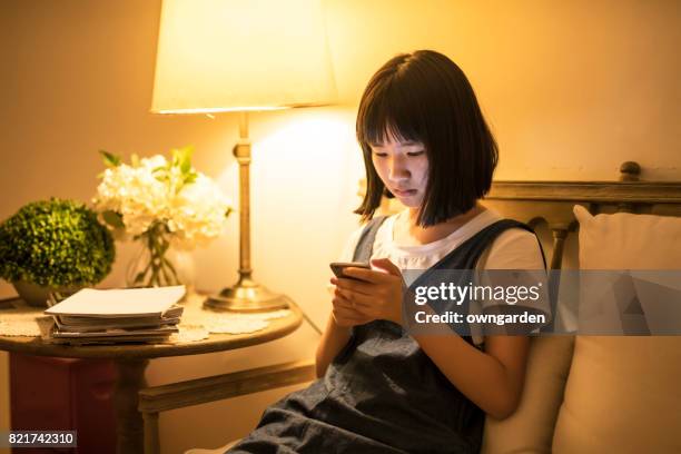 teenage girl using smartphone in the corridor - desk lamp stock pictures, royalty-free photos & images