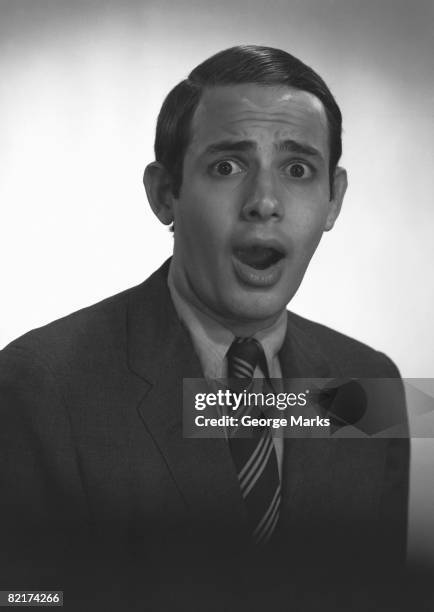 man posing in studio, mouth open, (b&w), portrait - glaring meaning stock pictures, royalty-free photos & images