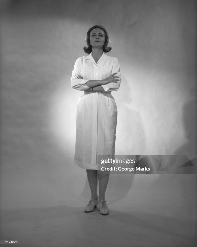 Woman in lab coat posing in studio, (B&W)