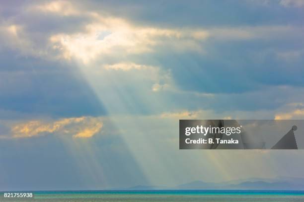 seascape with sunbeams at taketomi island in okinawa, japan - sunbeam clouds stock pictures, royalty-free photos & images