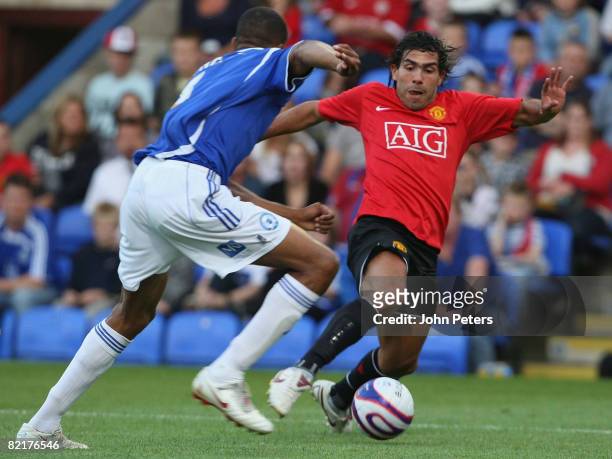 Carlos Tevez of Manchester United clashes with Shane Blackett of Peterborough United during the pre-season friendly match between Peterborough United...