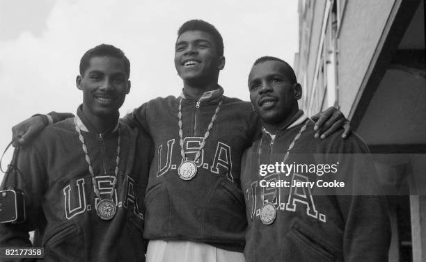 Rome Olympics: Portrait of USA Wilbert McClure , USA Cassius Clay , and USA Eddie Crook Jr. Victorious with gold medals at Piazza XVII Olimpiade....