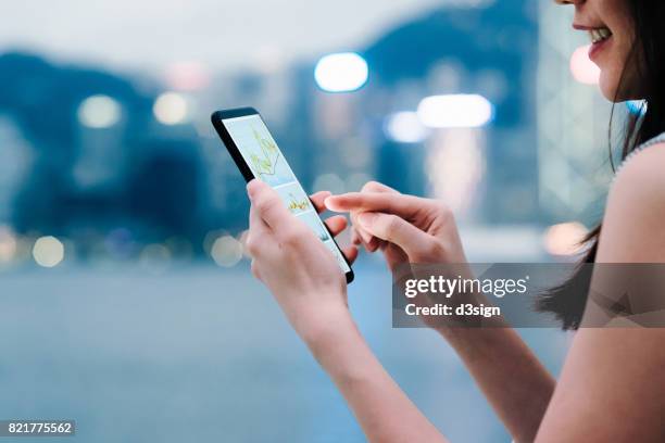 woman checking financial trading data with smartphone in city - financial planner stockfoto's en -beelden