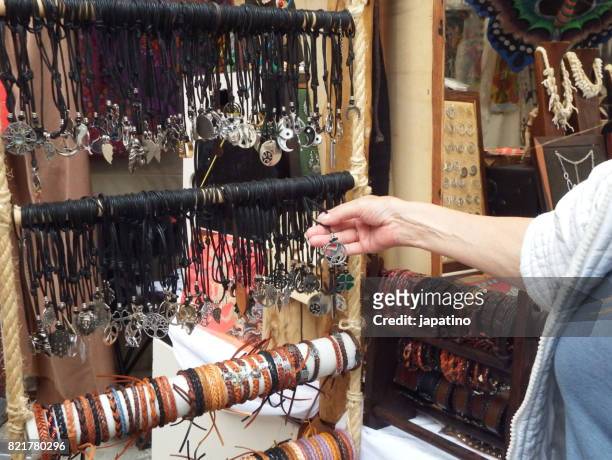 woman choosing a pendant in a street shop - diamant bijoux stock pictures, royalty-free photos & images