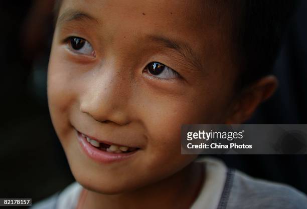 An orphan reacts to Chinese journalist Chen Xuebin who came to visit him at the Jiuxian Village on June 21, 2008 in Zhanjiang of Guangdong Province,...