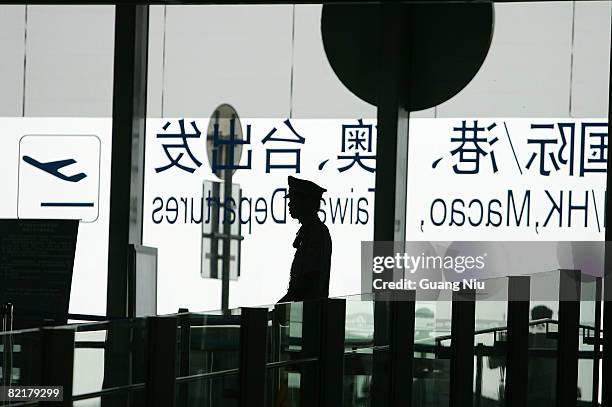 Chinese policeman stands guard at the entrance of Beijing Capital International Airport on August 5, 2008 in Beijing, China. China has tightened...