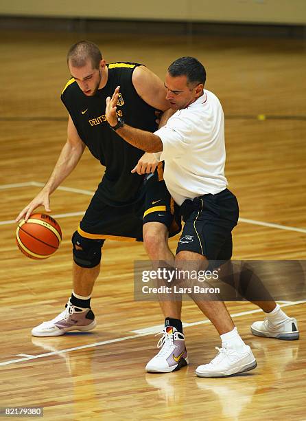 Tim Ohlbrecht and head coach Dirk Bauermann of Germany battle for the basketball during the practice session held at Shijingshan Gymnasium ahead of...