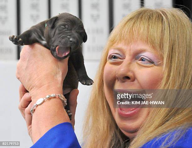 Bernann McKinney from Hollywood, California, smiles as she holds up a clone of her late beloved former pitbull terrier, at the Seoul National...