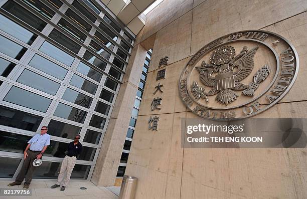 Security personnel stand guard in front the bullet proof glass wall of the new US embassy in Beijing on August 5, 2008. A massive new US embassy, the...