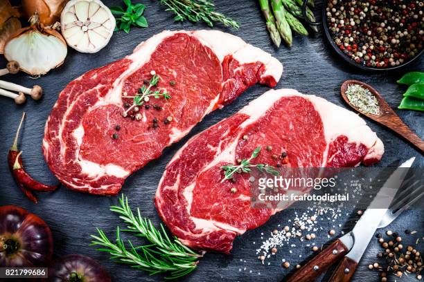raw fresh beef steak on dark background - beef stock pictures, royalty-free photos & images