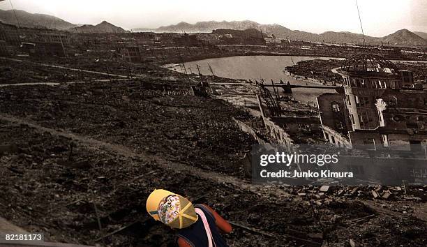 Boy looks at a picture, showing the aftermath of the atomic bomb attack dropped in the Hiroshima Peace Memorial Park on August 5, 2008 in Hiroshima,...