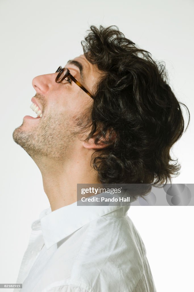 Man laughing, looking up, side view