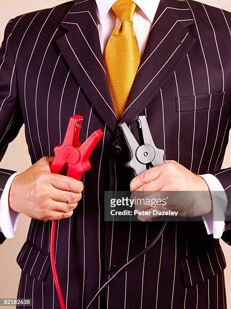 businessman holding jump leads in pinstripe suit - starthilfe stock-fotos und bilder