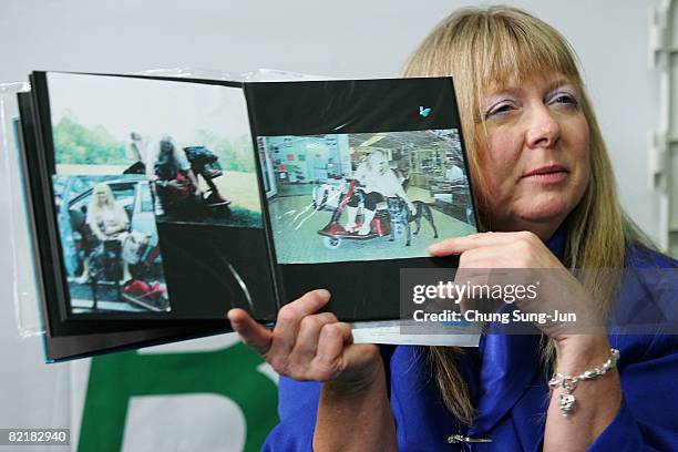 Bernann Mckinney shows the photos of her former pit bull terrier at the Seoul National University on August 5, 2008 in Seoul, South Korea. The Seoul...