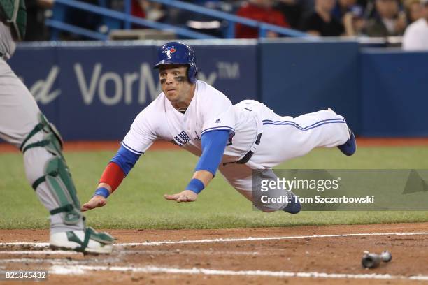 Steve Pearce of the Toronto Blue Jays is thrown out at home plate as he slides in the sixth inning during MLB game action against the Oakland...