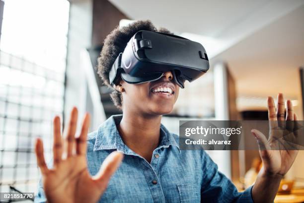 jonge vrouwelijke bij het opstarten met behulp van vr-bril - vr goggles business stockfoto's en -beelden